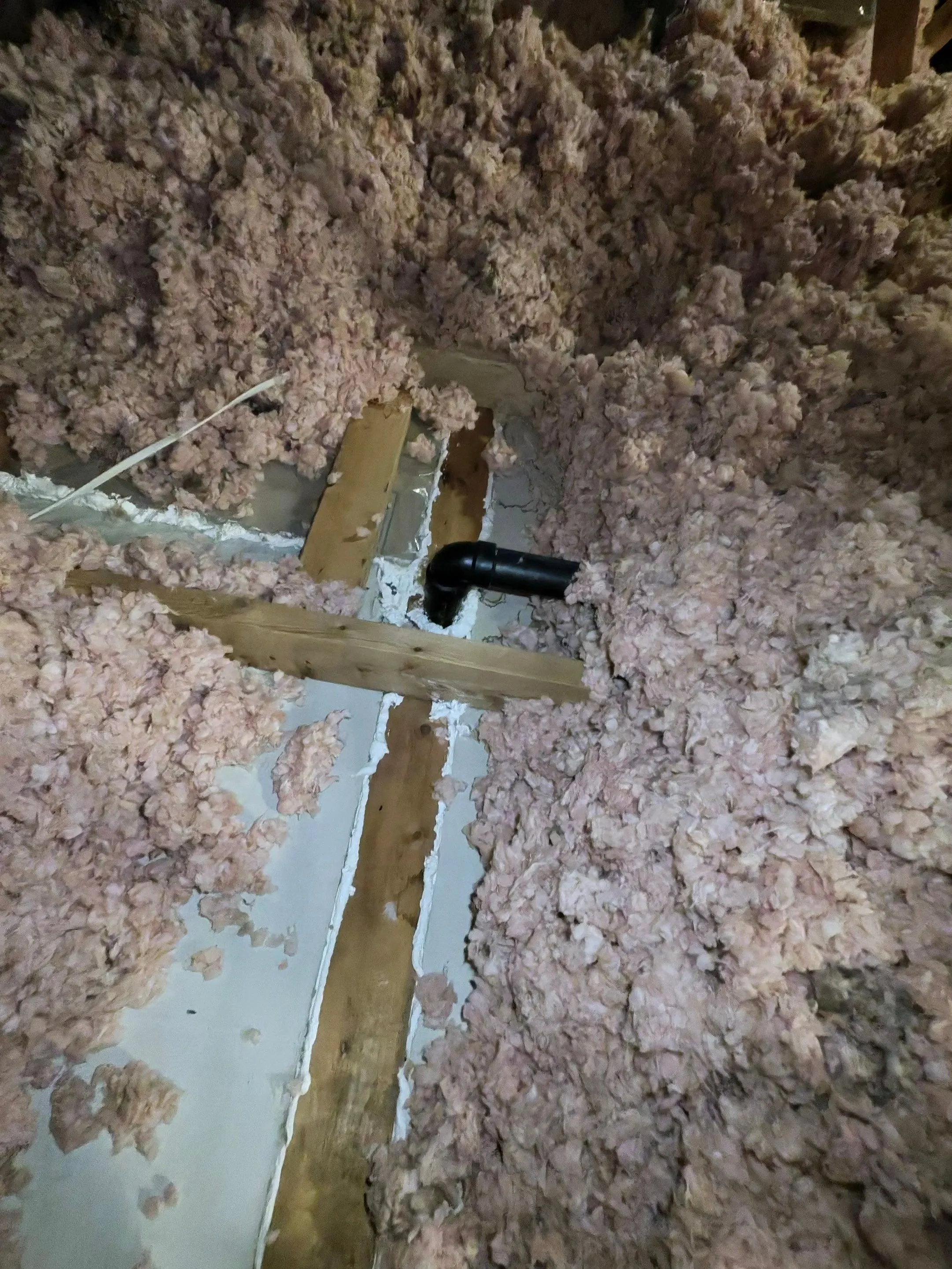 Blown-in insulation between attic framing around a plumbing vent