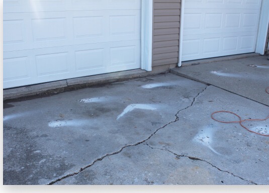 Cracked, sunken driveway before leveling