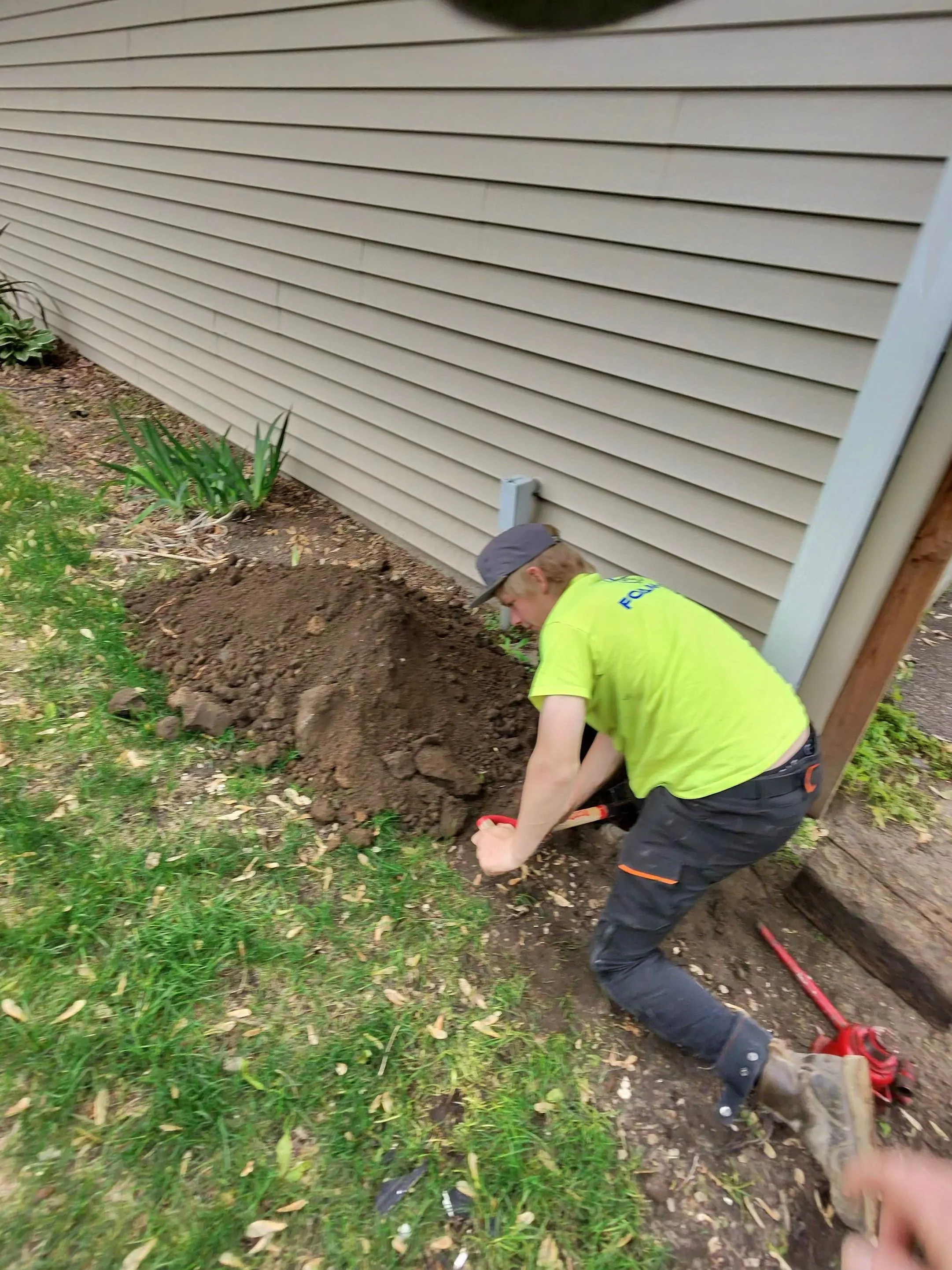 Foam-Tek technician working in an excavation along a home foundation